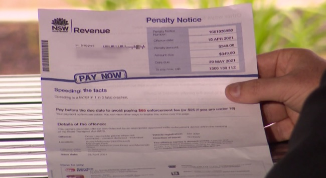 A hand holding a NSW penalty notice